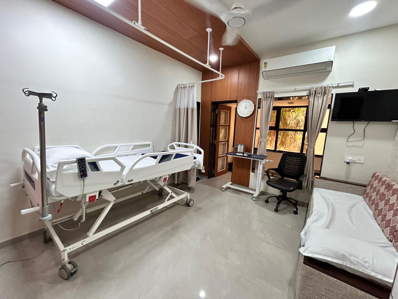Patient room with adjustable electric bed and bright window light.