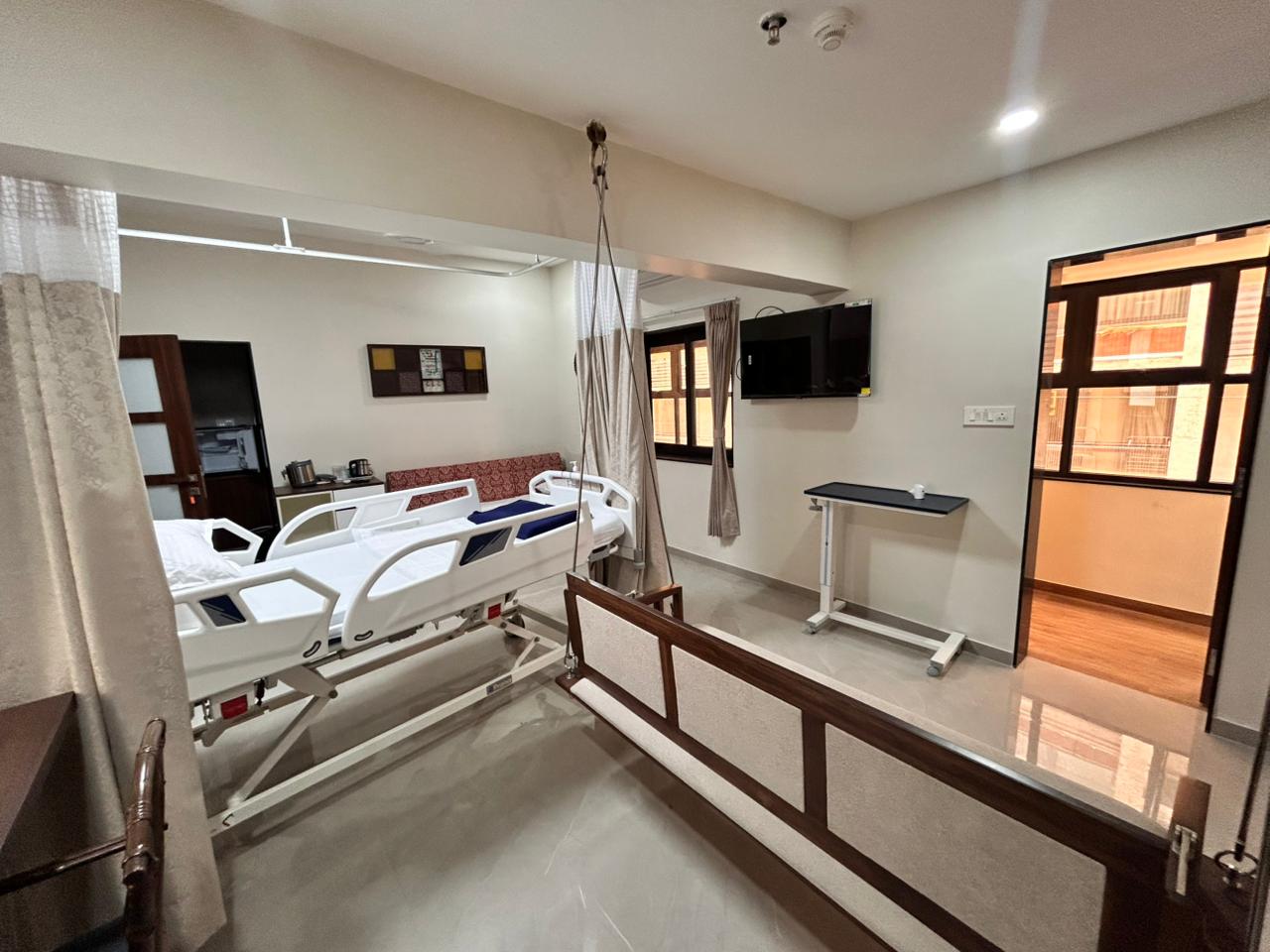 Attendant sofa-cum-bed with mini-fridge corner and glass partition.
